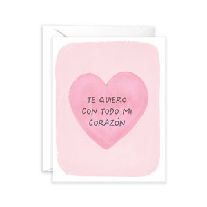 May include: A pink card with a watercolour heart and the text "Te quiero con todo mi coraz&oacute;n" in black.