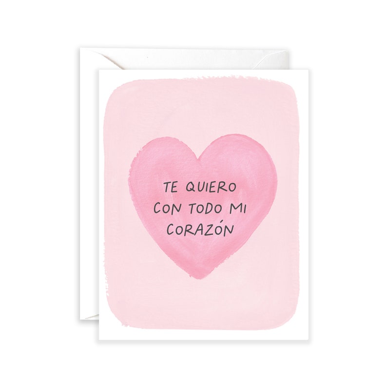 May include: A pink card with a watercolour heart and the text "Te quiero con todo mi coraz&oacute;n" in black.