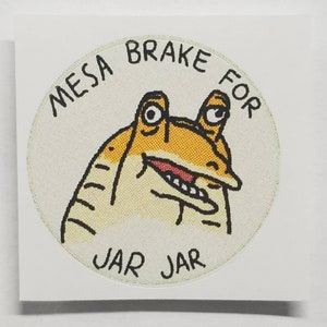 May include: A white circular sticker with a cartoon illustration of a yellow character with large eyes and a wide mouth. The text "MEEsa BRAKe FOR JAR JAR" is written around the character.