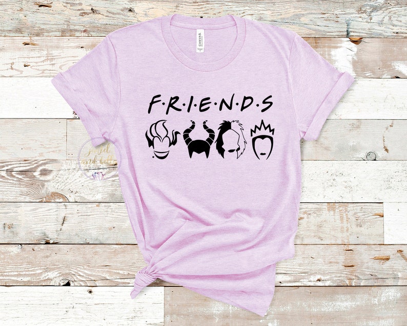 Puede incluir: Una camiseta de color morado claro con el texto "F.R.I.E.N.D.S" en negro. Debajo del texto hay cinco siluetas negras de villanos de Disney: &Uacute;rsula, Mal&eacute;fica, Cruella de Vil, la Reina Malvada y la Reina de Corazones.