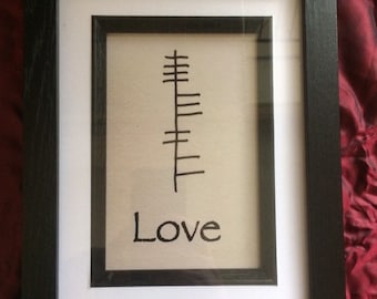 May include: A framed print with a black and white symbol and the word "Love" written below it.