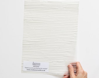 Könnte beinhalten: Ein weißes, strukturiertes Muster von Japondi-Tapete. Das Muster wird in der Hand gehalten und hat den Text "CREATE YOUR WORLD" und "Vielen Dank für den Kauf dieses Musters" aufgedruckt.