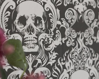 Könnte beinhalten: Schwarz-weiße Damast-Tapete mit einem Totenkopf-Design. Der Totenkopf befindet sich in der Mitte des Bildes und ist von komplizierten floralen Mustern umgeben.