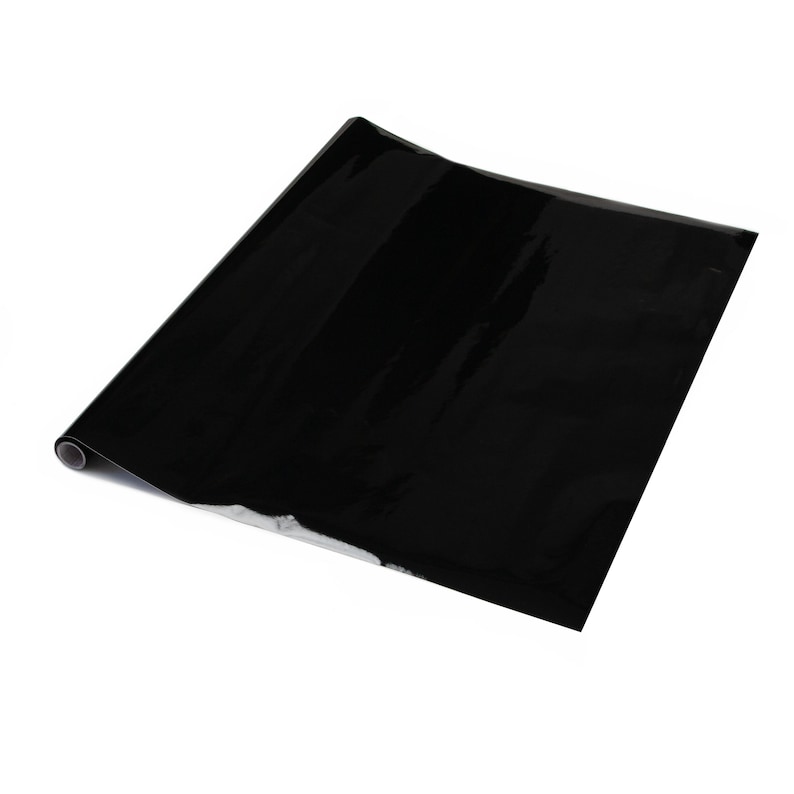 K&ouml;nnte beinhalten: Eine Rolle schwarzes, gl&auml;nzendes, selbstklebendes Vinylpapier. Das Papier ist aufgerollt und das Ende ist sichtbar.