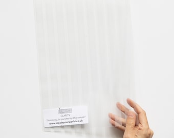 Könnte beinhalten: Eine transparente Plastikfolie mit vertikalen weißen Streifen. Die Folie hat ein kleines weißes Etikett mit dem Text "CREATE CLARITY" und "Thank you for purchasing this sample" und "www.createyourworld.co.uk".