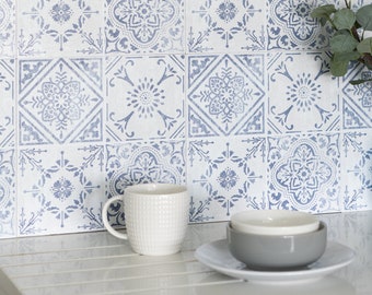 Könnte beinhalten: Eine weiße Arbeitsplatte mit einer blauen und weißen gemusterten Fliesenrückwand. Auf der Arbeitsplatte stehen eine weiße Tasse und zwei graue Schalen.