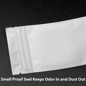 May include: White resealable pouch with a zipper seal. The pouch is made of a material that is smell proof and keeps odor in and dust out.