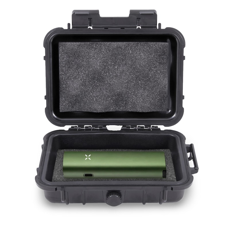 May include: An open black hard case with a green electronic device inside. The device has a small white X on it. The case has a foam insert and is designed to protect the device. The case is open and ready for use.