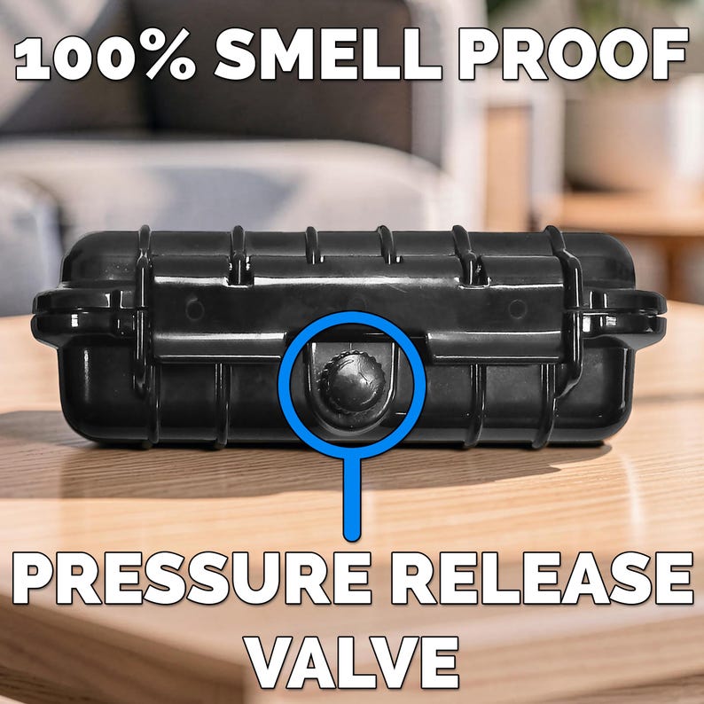 May include: A black, rectangular case with a pressure release valve. The text "100% SMELL PROOF" and "PRESSURE RELEASE VALVE" are displayed in white. The case is on a wooden surface.