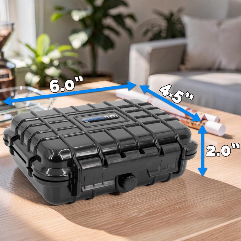 May include: A black, rectangular, waterproof case with a ribbed design. The case measures 6.0" long, 4.5" wide, and 2.0" high. It has a secure latch and is designed to protect contents from the elements. The case is on a wooden surface.