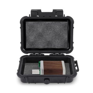 May include: An open black hard case with a foam interior, containing a wooden and silver device. The device has a USB connector. The case is designed to protect the device during transport and storage.