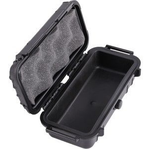 May include: Black rectangular waterproof case, open to reveal a gray foam interior and a black empty compartment. The case has a hinged lid with a latch and a small dial on the side.