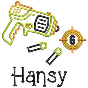 May include: A green and yellow toy gun with black bullets and a target with the number 6 in the center. The name "Hansy" is written below the target.
