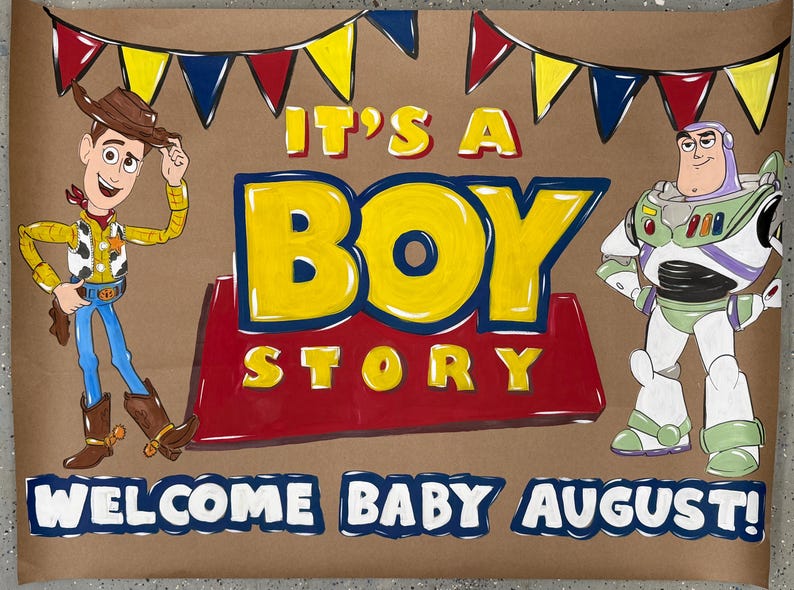 May include: A brown poster with the words "It's a Boy Story" in yellow and red, featuring cartoon characters Woody and Buzz Lightyear. The text "Welcome Baby August!" is at the bottom, with colorful bunting at the top.