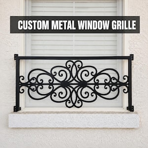 May include: A black metal window grille featuring a symmetrical scrollwork design with intricate swirling patterns. The rectangular frame is mounted to the exterior wall, with the text CUSTOM METAL WINDOW GRILLE displayed at the top.