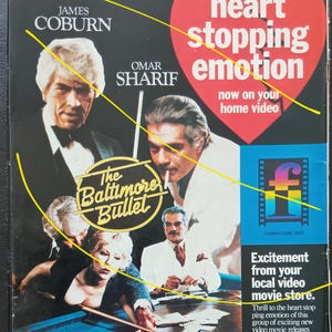 May include: A vintage VHS movie cover for "The Baltimore Bullet" featuring James Coburn and Omar Sharif. The cover has a heart graphic with the words "heart stopping emotion." The movie is described as a drama about a million-dollar pool battle.