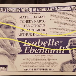 May include: A vintage movie poster for "Isabelle Eberhardt" featuring Mathilda May and Peter O'Toole. The poster has a purple banner with the movie title and the text "A VISUALLY RAVISHING PORTRAIT OF A SINGULARLY FASCINATING WOMAN". The film starts September 18th.