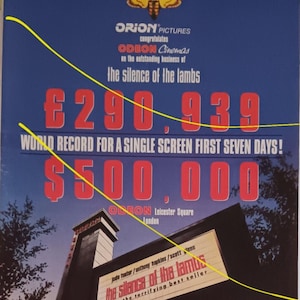 May include: A movie poster for "The Silence of the Lambs" with a moth graphic. The poster highlights box office records, including a world record for the first seven days and a single-day record. The film's title and cast are also displayed.
