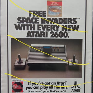 May include: An advert for the Atari 2600 video game console, featuring the console, two joysticks, and a Space Invaders game box. Text states "FREE SPACE INVADERS WITH EVERY NEW ATARI 2600."