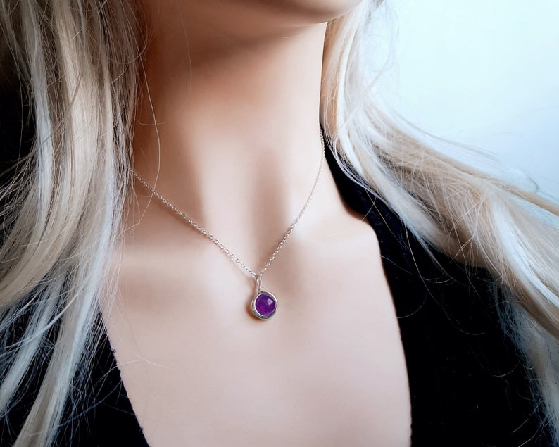 Peut inclure: Un collier en cha&icirc;ne argent avec un petit pendentif rond en pierre pr&eacute;cieuse violette.
