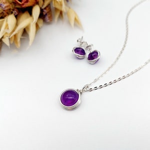 Peut inclure: Un collier et des boucles d'oreilles en argent avec des pierres d'am&eacute;thyste violettes. Les pierres sont serties dans des montures en fil de fer.
