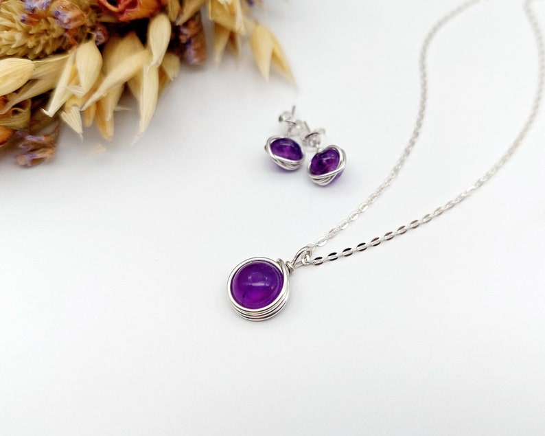 Peut inclure: Un collier et des boucles d'oreilles en argent avec des pierres d'am&eacute;thyste violettes. Les pierres sont serties dans des montures en fil de fer.