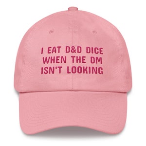 May include: Pink baseball cap with the text "I eat D&D dice when the DM isn't looking" embroidered in pink.