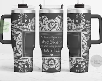 Puede incluir: Un vaso de acero inoxidable negro con asa y pajita, decorado con un diseño floral en blanco y negro. El vaso tiene el texto "To the world you are a Mother, to your family you are the World".