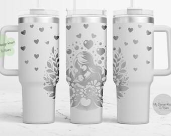 Puede incluir: Un vaso de acero inoxidable blanco con asa. El vaso presenta un diseño de una madre sosteniendo un bebé con corazones y flores. El texto "My Design Room To Yours" está en el vaso.