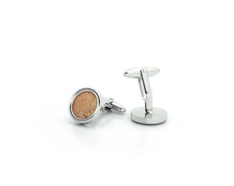 May include: A pair of silver cufflinks with a round, light brown wood inlay.