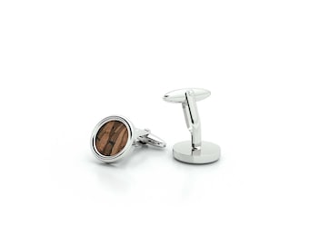 May include: A pair of silver cufflinks with a round, brown wood inlay.