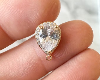 May include: Gold teardrop pendant with a clear crystal and a halo of smaller crystals.