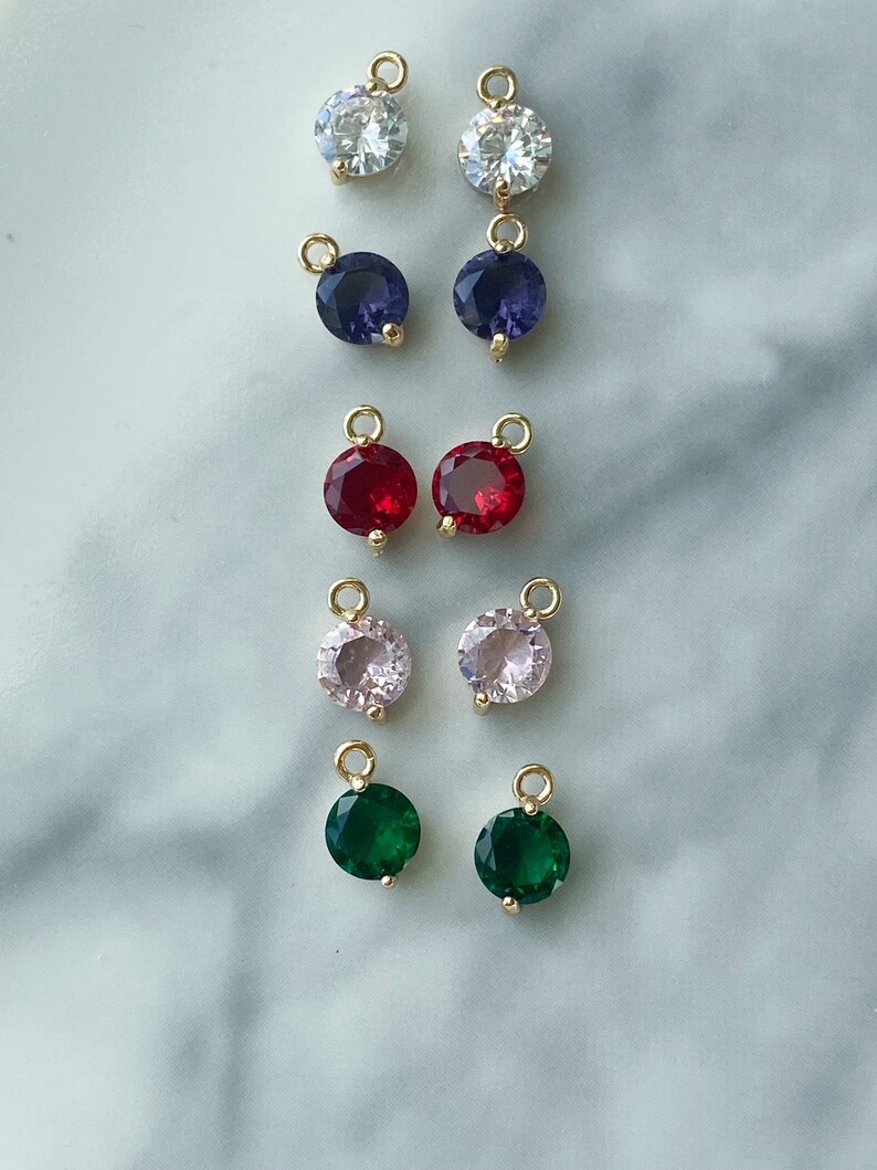 Puede incluir: Surtido de 10 colgantes de amuleto de tono dorado con piedras preciosas redondas y facetadas. Las piedras preciosas son transparentes, moradas, rojas, rosas y verdes.