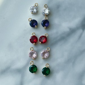 Puede incluir: Surtido de 10 colgantes de amuleto de tono dorado con piedras preciosas redondas y coloridas. Los amuletos presentan piedras preciosas transparentes, azules, rojas, rosas y verdes.