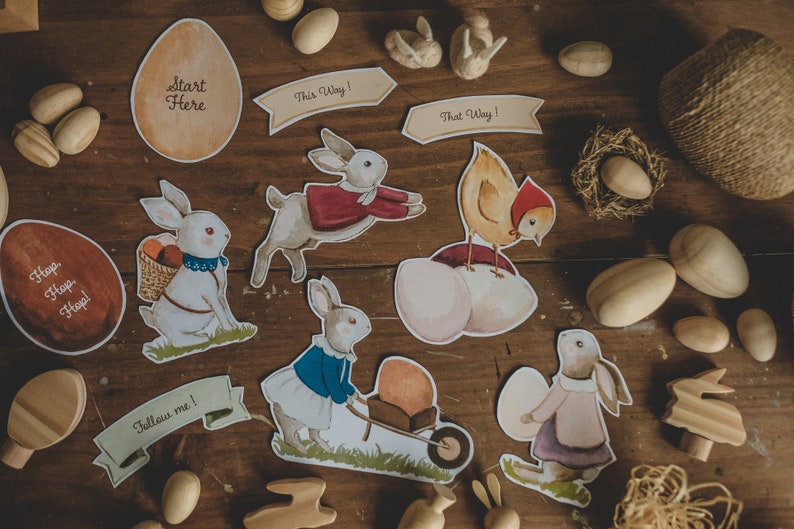 K&ouml;nnte beinhalten: Ein Set an Ostern-Dekorationen mit Hasen, einem K&uuml;ken und Eiern. Die Dekorationen sind auf Karton gedruckt und beinhalten S&auml;tze wie "Hop Hop Hop!" und "Folge mir!"
