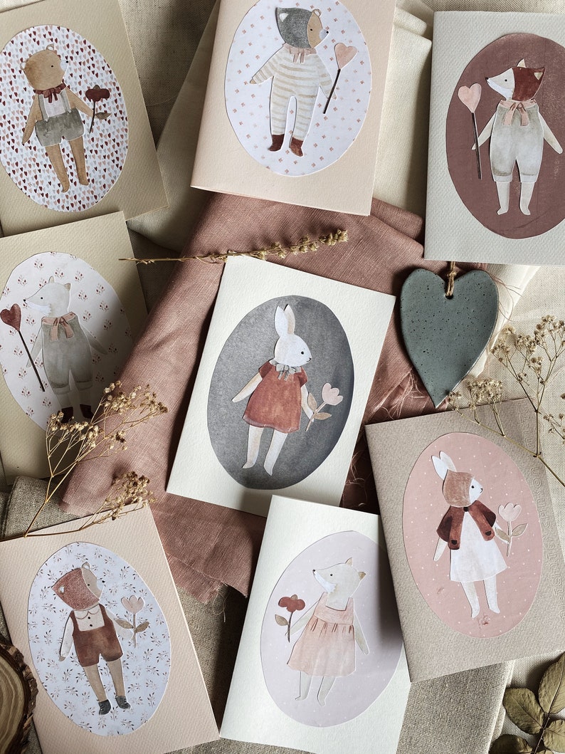 Puede incluir: Conjunto de ocho tarjetas ilustradas con diferentes animales, incluyendo un oso, un zorro, un conejito y un gato. Cada tarjeta tiene un dise&ntilde;o circular con un fondo rosa, marr&oacute;n o gris y un borde blanco. Las tarjetas son perfectas para enviar un mensaje especial o agregar un toque de fantas&iacute;a a la decoraci&oacute;n de tu hogar.
