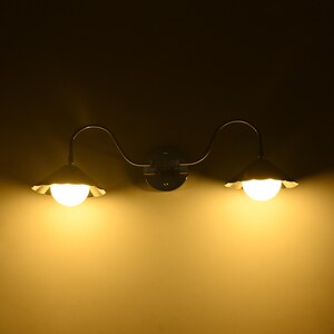 Contemporary silver wall lamp with two downward facing globe lights and curved detailing