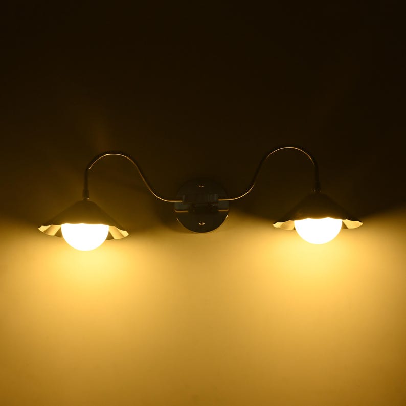 Contemporary silver wall lamp with two downward facing globe lights and curved detailing