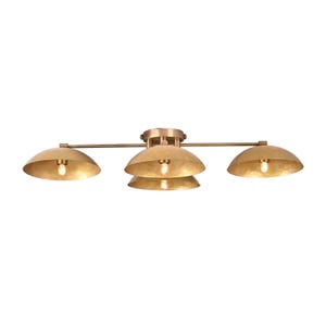 May include: A brass-toned ceiling light fixture with four dome-shaped shades. The fixture has a horizontal bar with three lights and a central cluster of two lights. Each shade houses a visible light bulb.