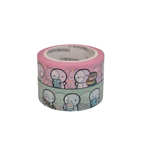 Puede incluir: Dos rollos de cinta adhesiva decorativa. Un rollo es rosa con corazones blancos y figuras de dibujos animados. El otro rollo es turquesa con figuras de dibujos animados. El texto "THECOFFEEMONSTERCO" está impreso en la cinta.