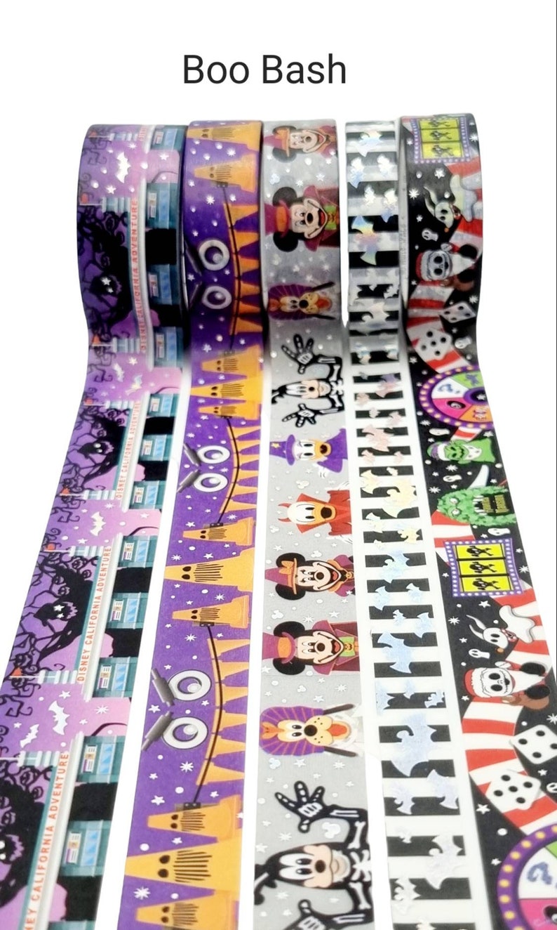 May include: Five rolls of washi tape featuring a Halloween theme with Mickey Mouse and other Disney characters. The tape is purple, orange, grey, black, and white with a variety of designs including ghosts, bats, and stars.
