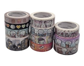 Puede incluir: Una colección de once rollos de cinta decorativa washi dispuestos en tres pilas. Cada rollo presenta varias ilustraciones de personajes, paisajes urbanos, corazones y motivos de comida con el texto THECOFFEEMONSTERCO impreso en el núcleo.