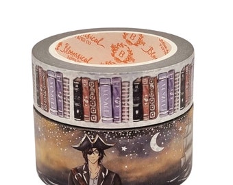 May include: Two rolls of washi tape. The top roll features a bookshelf with rows of colorful books. The bottom roll features a pirate with a black eye patch standing on a ship at sea under a starry night sky.