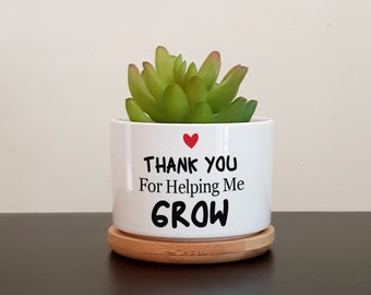 May include: White ceramic planter with a small succulent plant and a red heart. The planter has the text "Thank You For Helping Me GROW" printed on it.