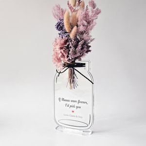 May include: A clear acrylic vase shaped like a mason jar with a bouquet of dried flowers in shades of pink and purple. The vase has a quote that reads "If humans were flowers, I'd pick you" with a small red heart and the text "Love Claire & Issy".