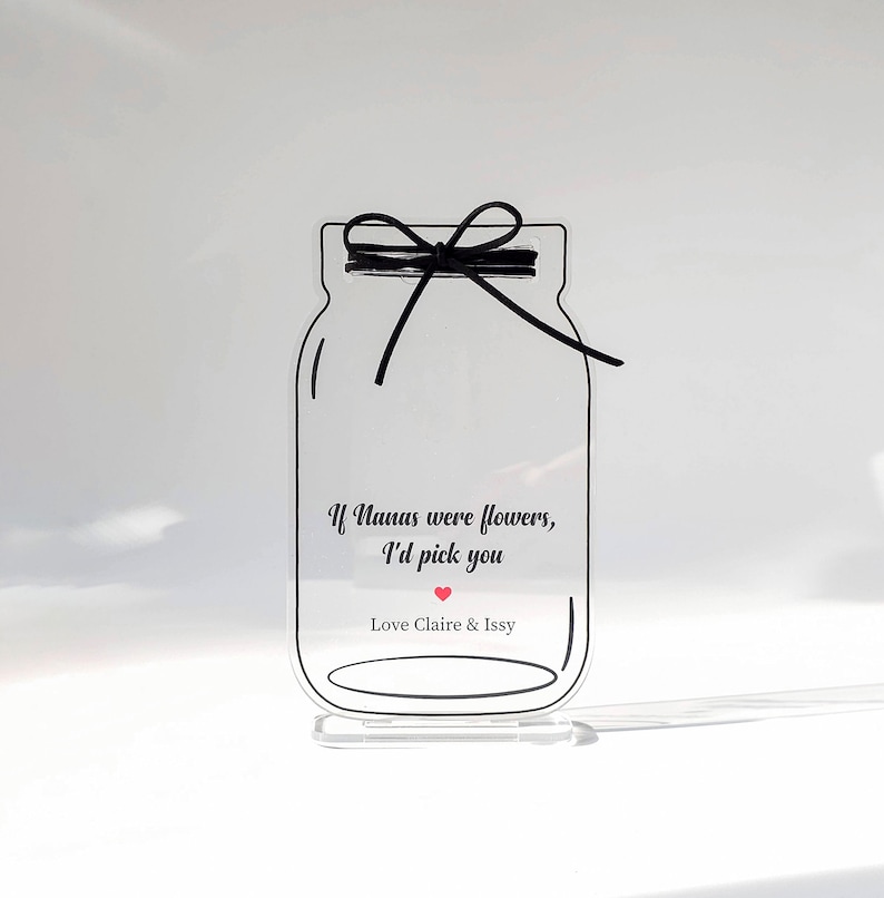 May include: A clear acrylic jar with a black ribbon tied around the top. The jar has a message that reads "If Nanas were flowers, I'd pick you" with a red heart. The jar is on a clear acrylic stand. Love Claire & Issy.