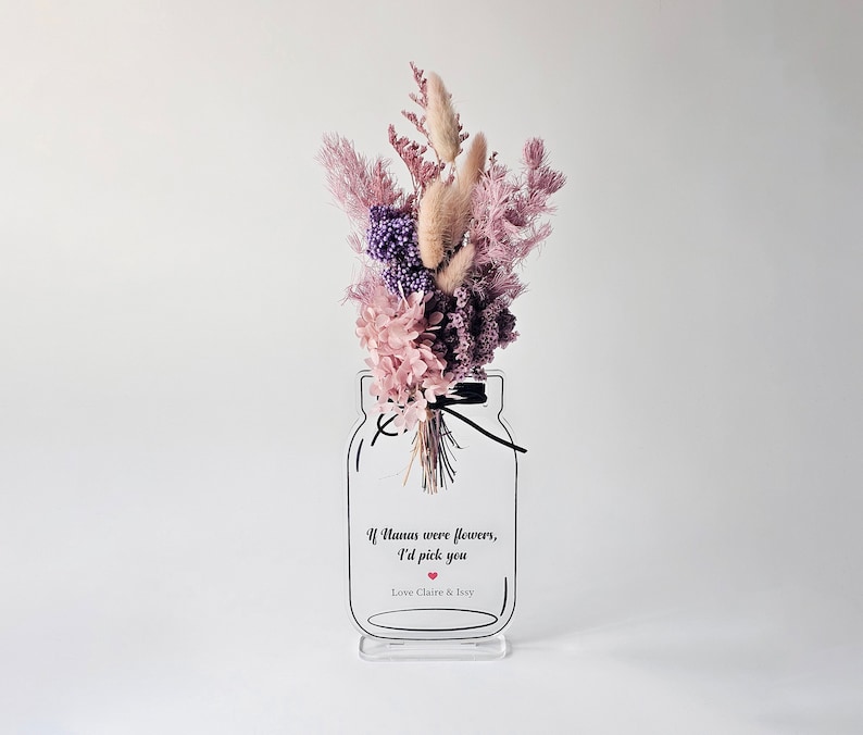 May include: A clear acrylic vase with a mason jar design, filled with a bouquet of dried flowers in shades of pink and purple. The vase has a quote that reads "If humans were flowers, I'd pick you" with a small red heart. The vase is on a white background.