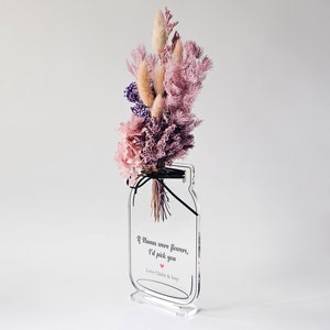 May include: A clear acrylic vase with a bouquet of dried flowers in shades of pink and purple. The vase has a quote on it that reads "If humans were flowers, I'd pick you."  Love Claire & Issy.
