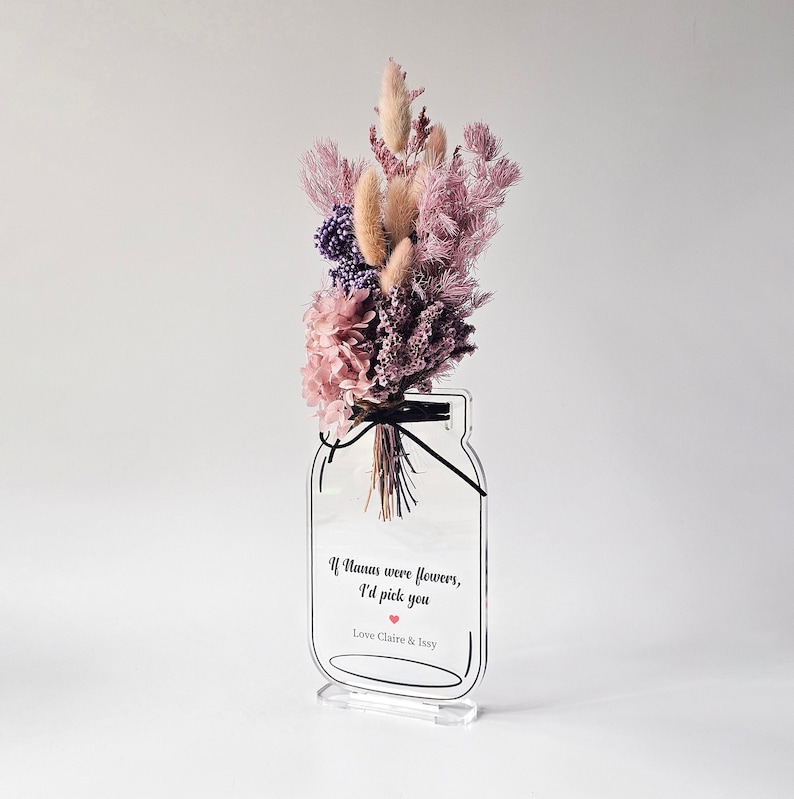 May include: A clear acrylic vase shaped like a mason jar with a bouquet of dried flowers in shades of pink and purple. The vase has a quote that reads "If humans were flowers, I'd pick you" with a small red heart and the text "Love Claire & Issy".