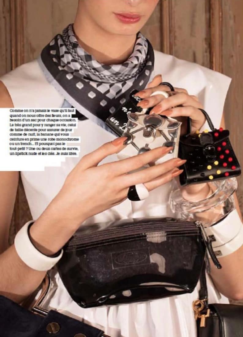 May include: A fashion-forward image featuring a black and white patterned scarf, a clear fanny pack, and several small, decorative handbags. One handbag is black with red and yellow accents. The image also includes text in French.